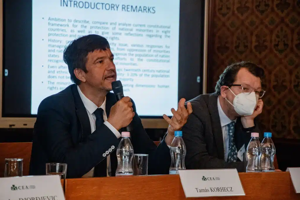 Man giving a presentation behind a microphone with a projector in the background