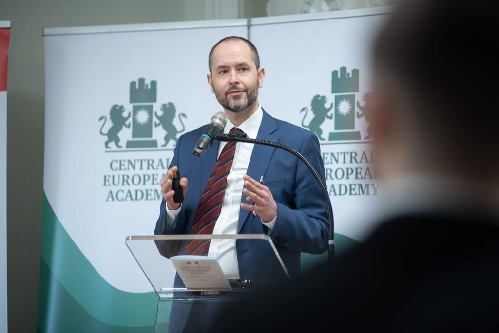Férfi előadó beszédet tart a CEA logója előtt