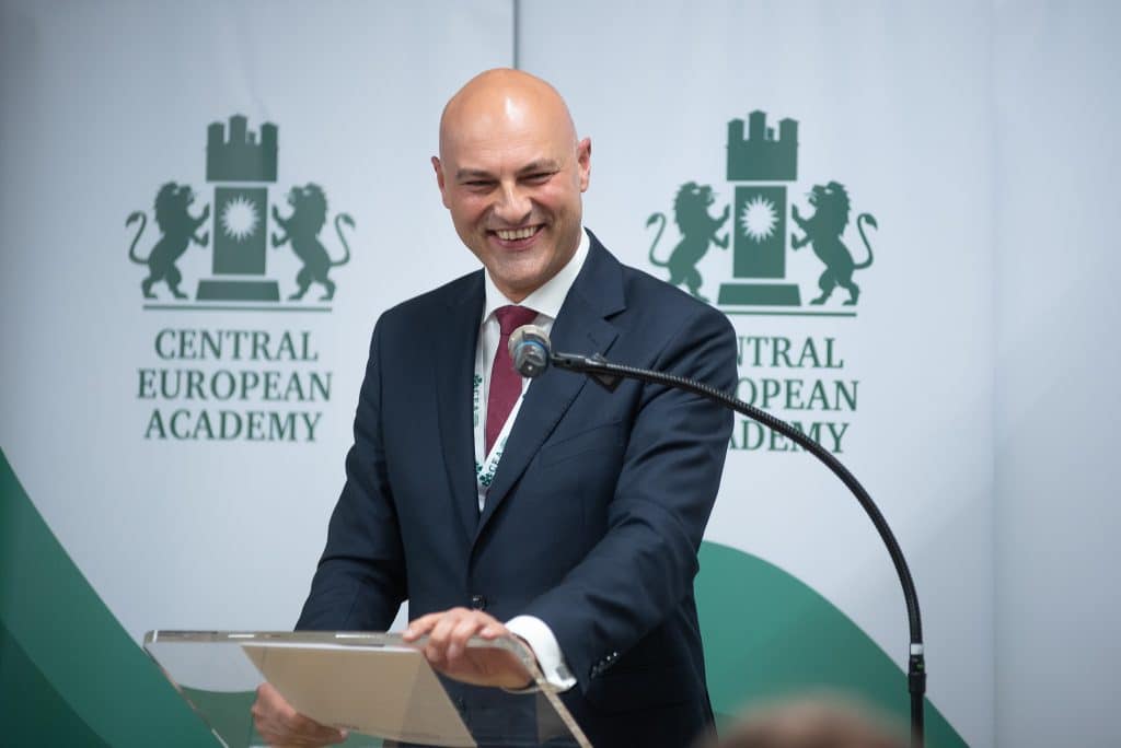 Férfi előadó beszédet tart a CEA logója előtt