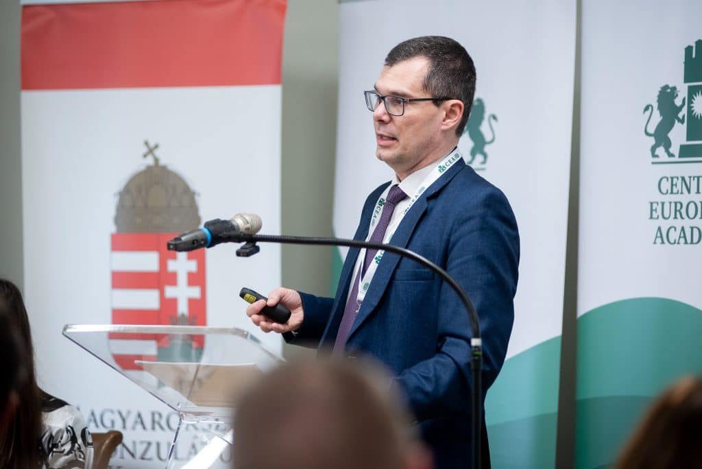 Férfi előadó beszédet tart a CEA logója előtt