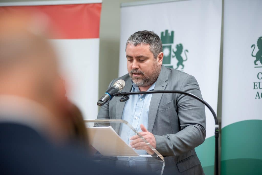 Férfi előadó beszédet tart a CEA logója előtt