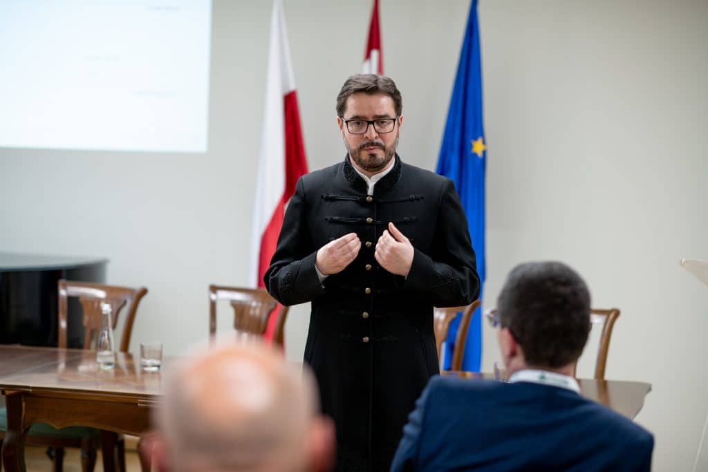 Férfi előadó beszédet tart a CEA logója előtt