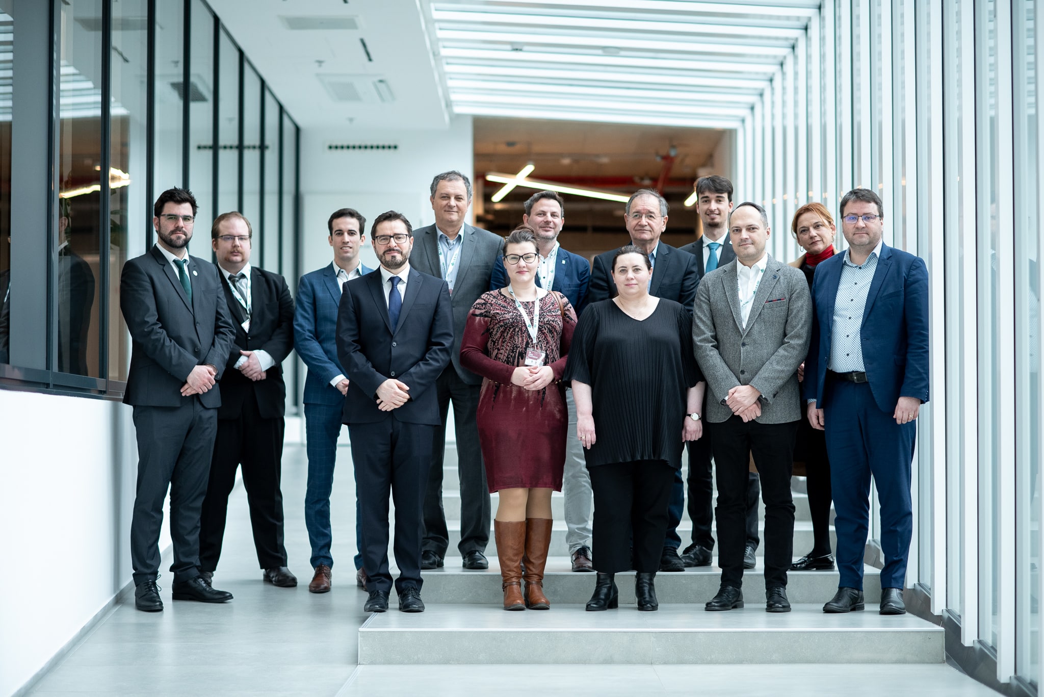 Öltönyös csoportkép a konferencián résztvevőkkel