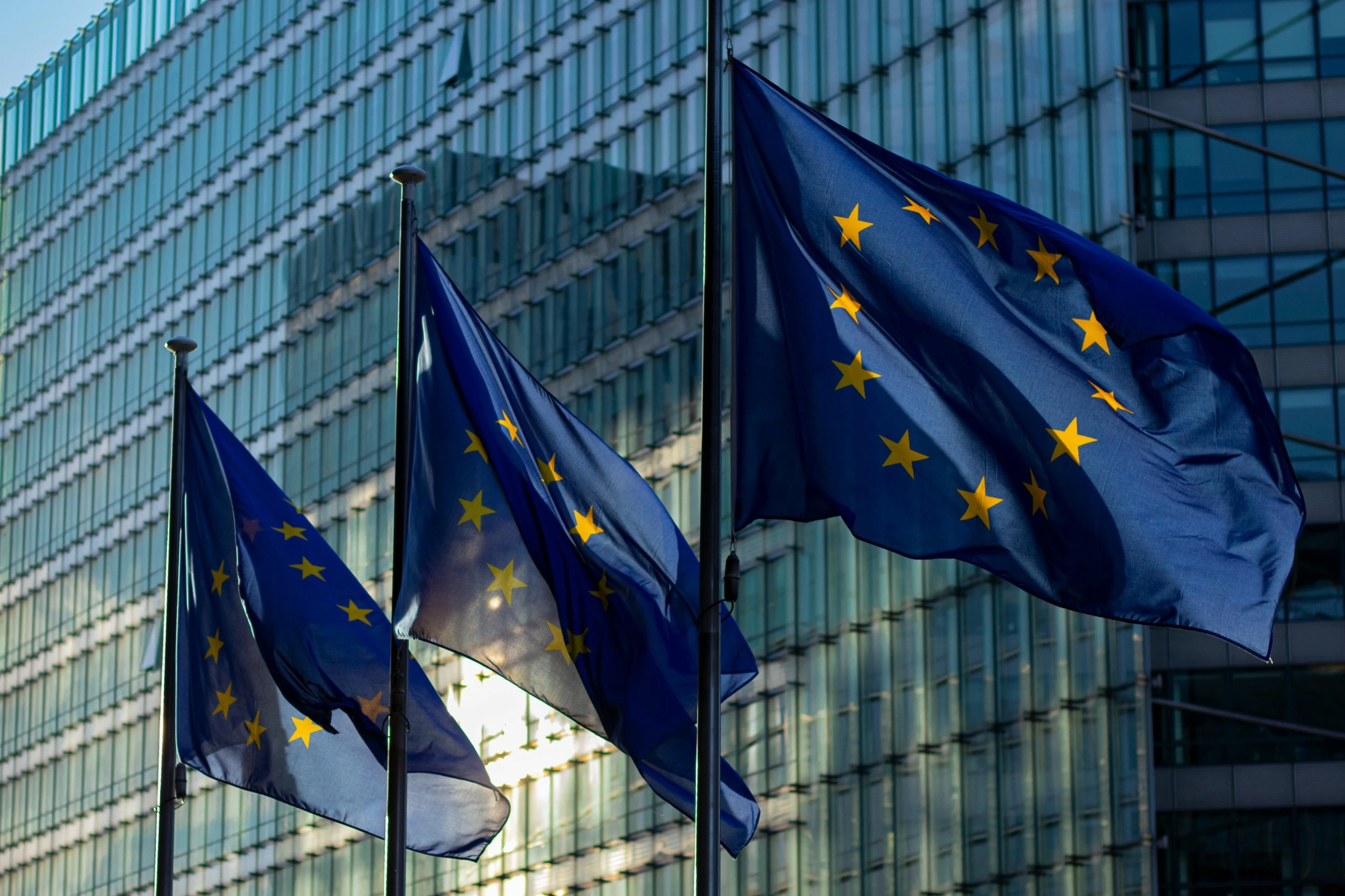 Európai Unió zászlói modern üvegépület előtt