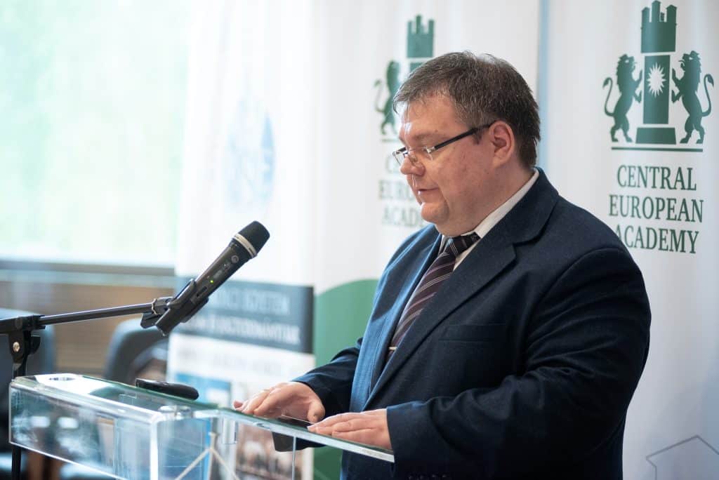 Férfi előadó beszél a CEA pódiumán, hallgatóság előtt
