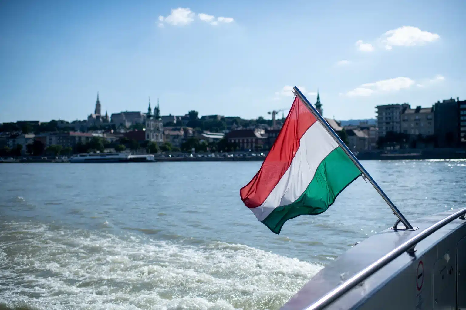 Magyar zászló lobog egy hajón, háttérben Budapest látképe a Dunánál