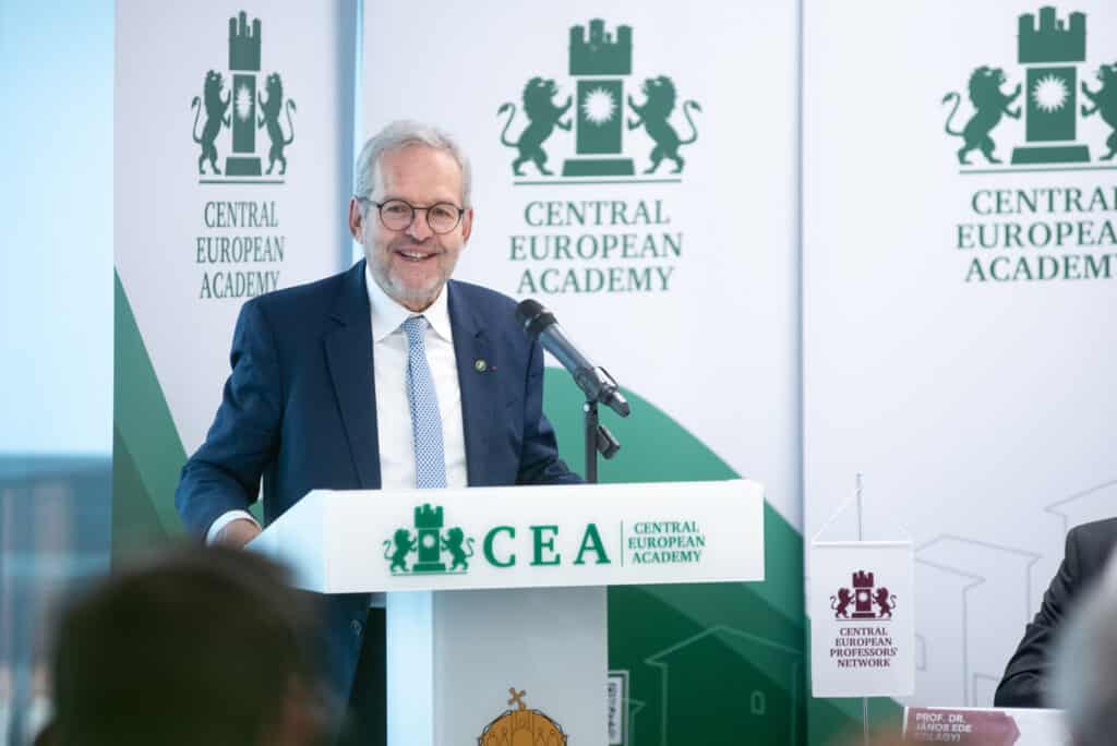 Férfi előadó beszél a CEA pódiumán, hallgatóság előtt