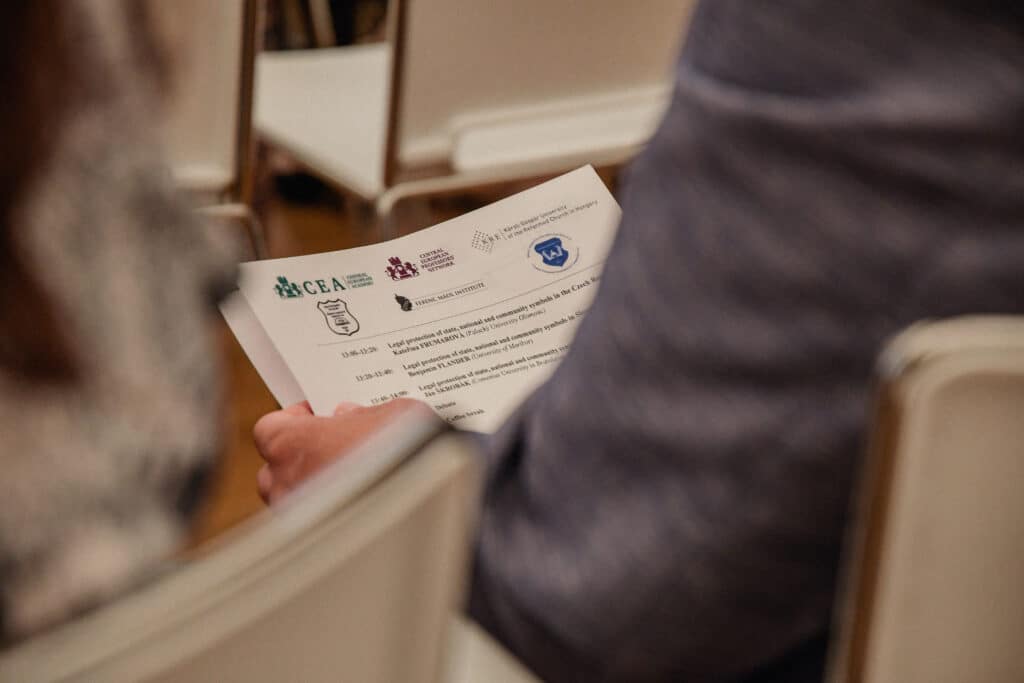 Résztvevő könyvet tart a kezében, konferencián