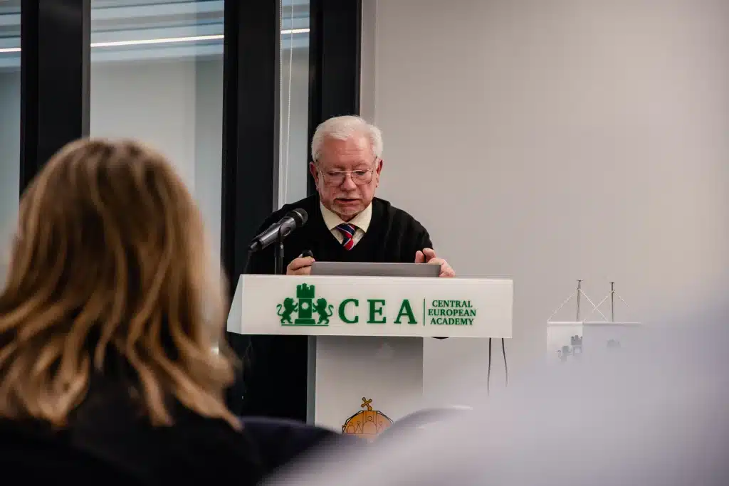 Férfi előadó beszél a CEA pódiumán, hallgatóság előtt