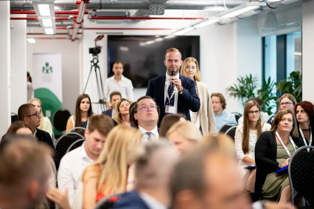 Man standing at a microphone asking a question