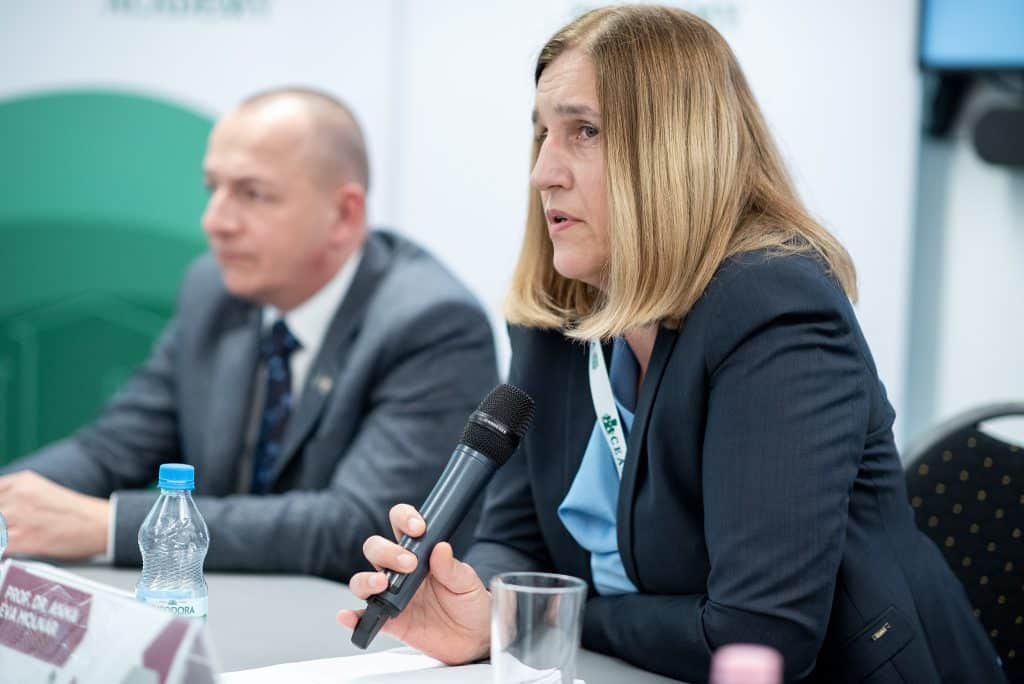 Női előadó beszél a CEA pódiumán, hallgatóság előtt