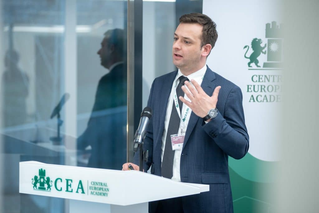 Férfi előadó beszél a CEA pódiumán, hallgatóság előtt