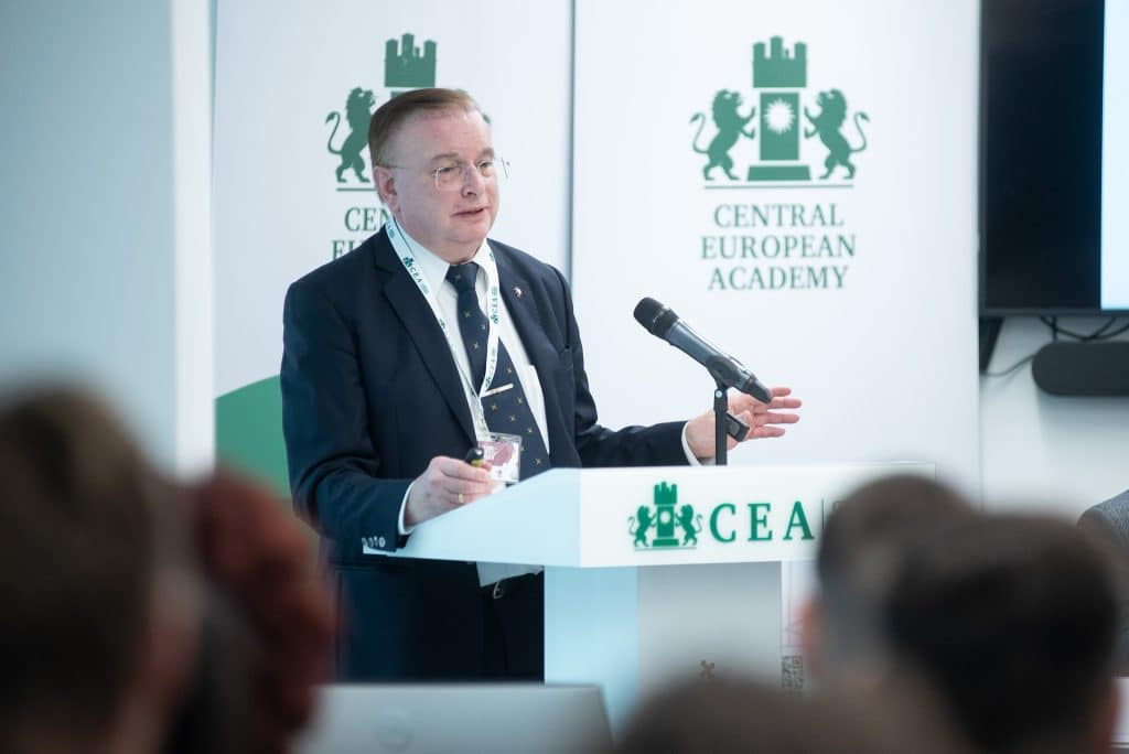 Férfi előadó beszél a CEA pódiumán, hallgatóság előtt