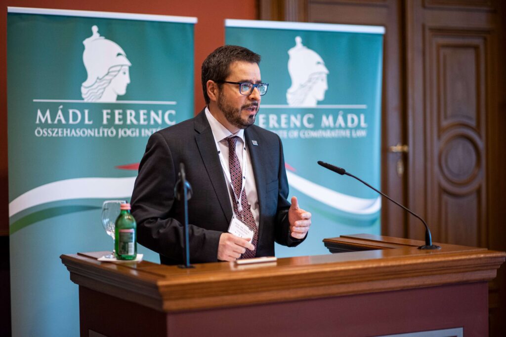 Male speaker giving a speech in front of the Central European Academy logo