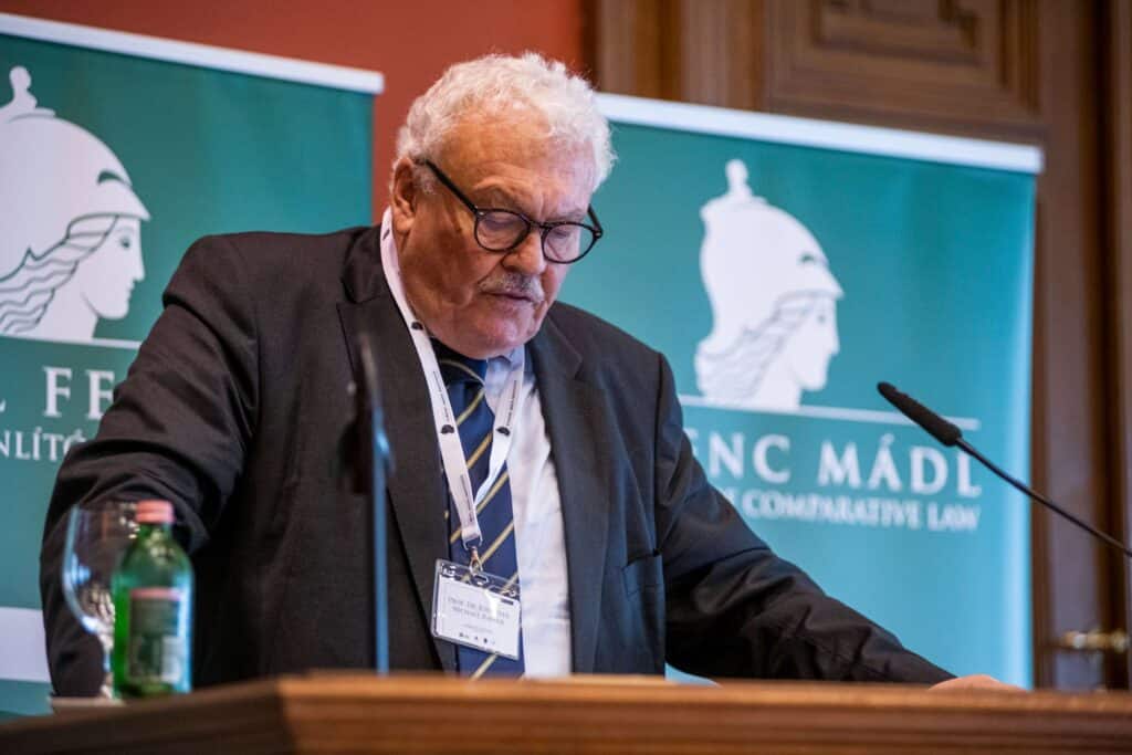 Male speaker giving a speech in front of the Central European Academy logo