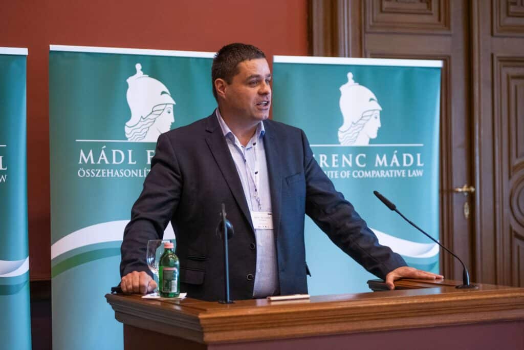 Male speaker giving a speech in front of the Central European Academy logo