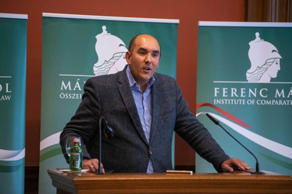Male speaker giving a speech in front of the Central European Academy logo