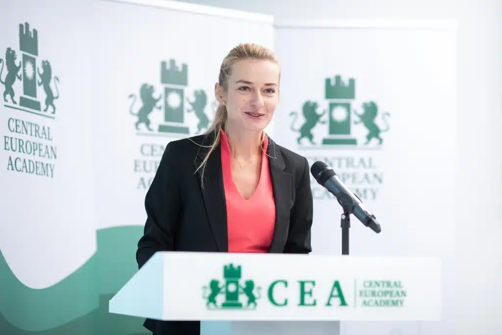 Női előadó beszél a CEA pódiumán, hallgatóság előtt