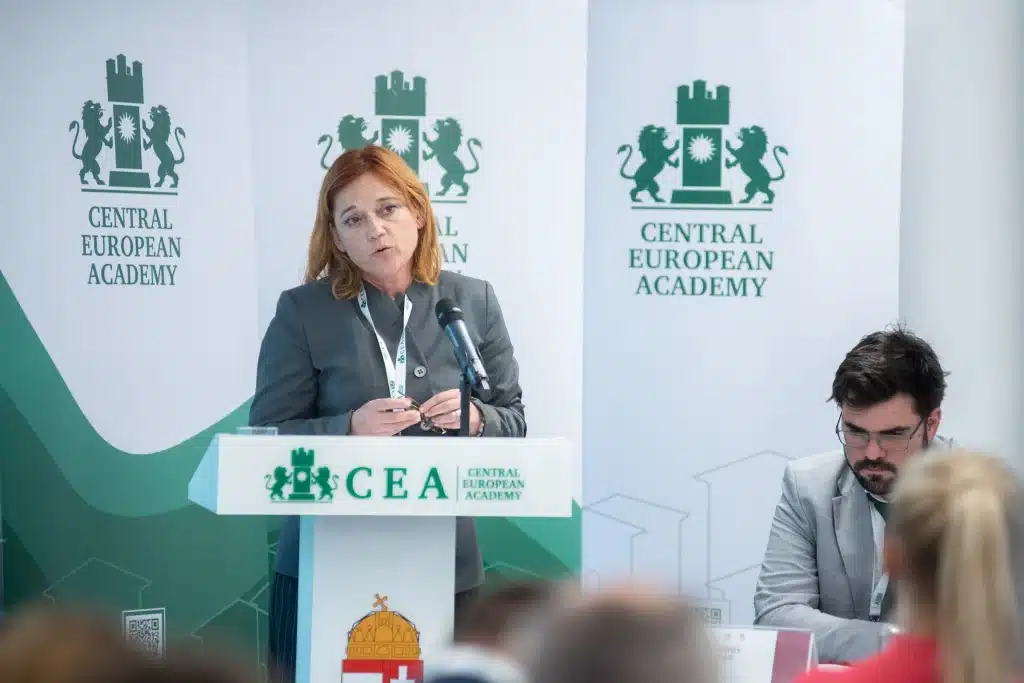 Női előadó beszél a CEA pódiumán, hallgatóság előtt