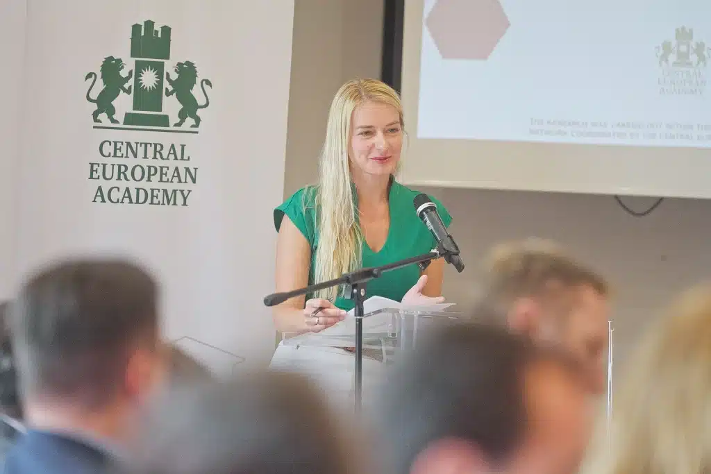 Női előadó beszél a CEA pódiumán, hallgatóság előtt