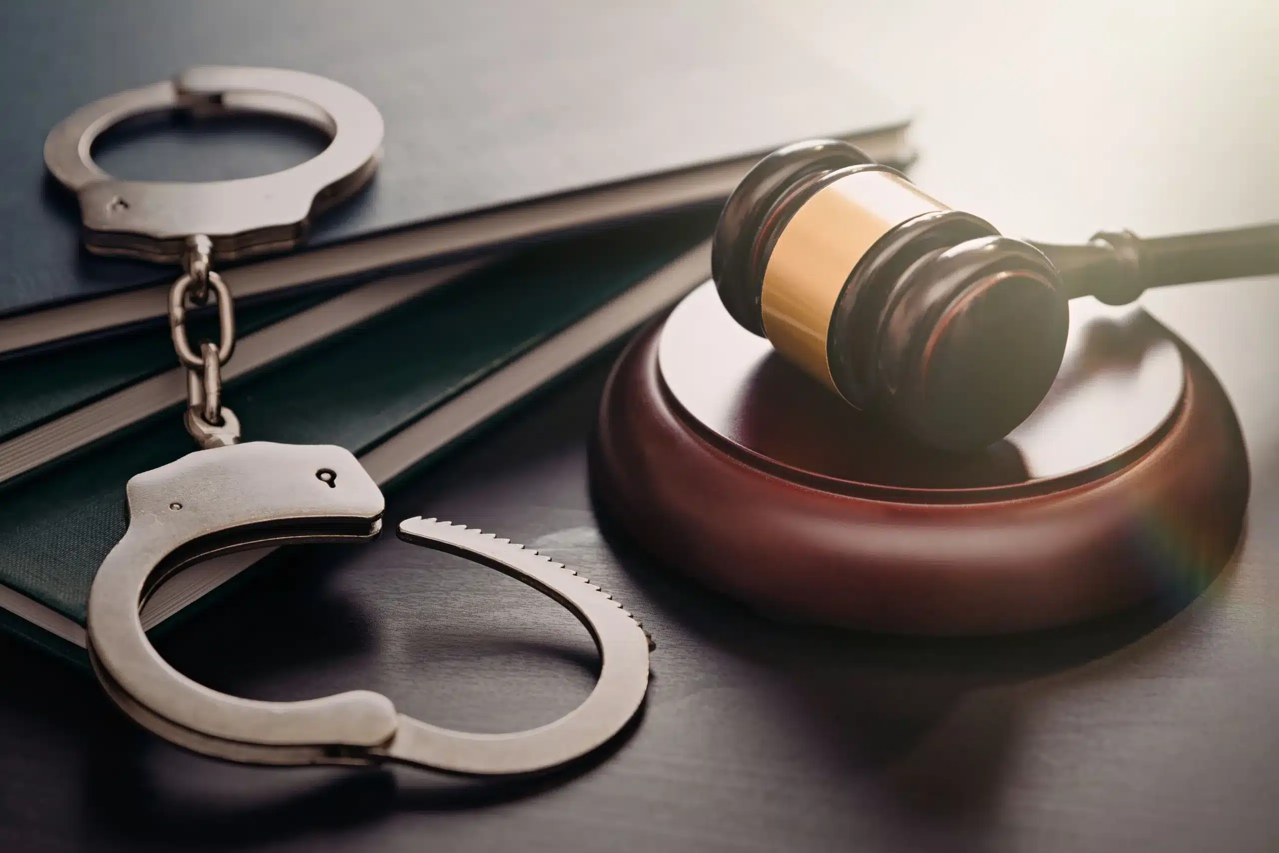 Scales of justice and a handcuff symbolizing law and justice.