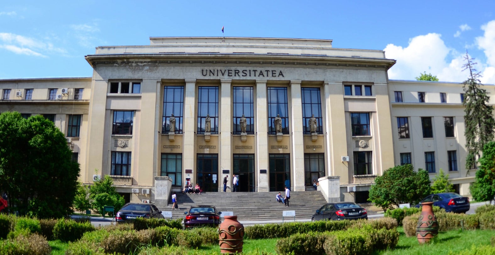 Monumental university building with a colonnade and inscription