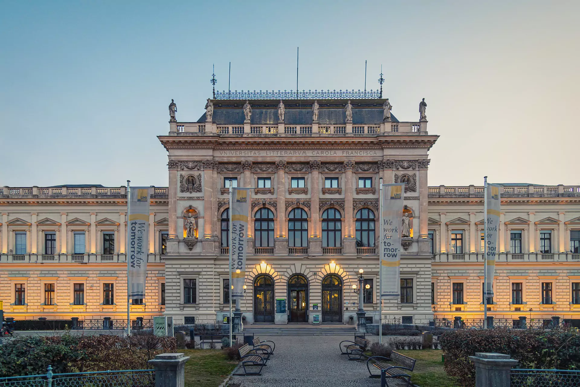 Historic university building illuminated at dusk