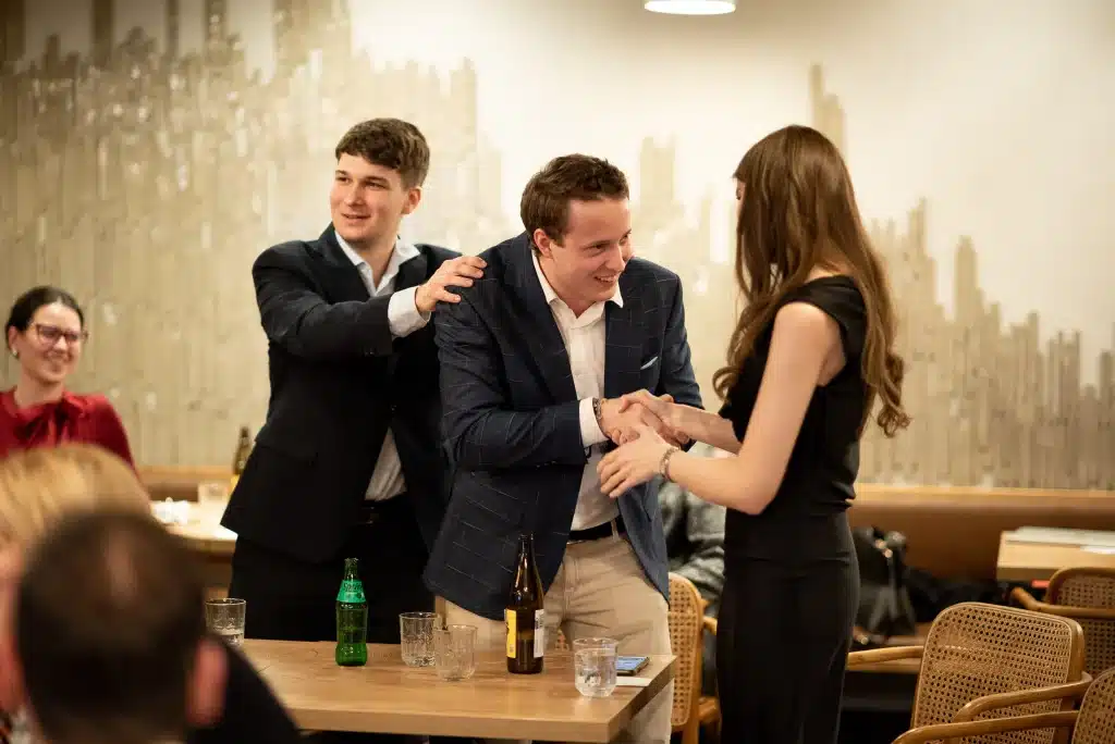 Man greeting a woman with a handshake