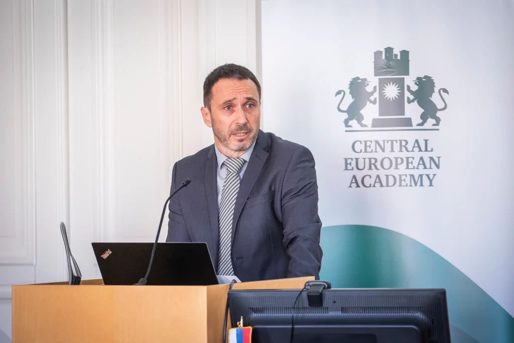 Férfi előadó beszél a CEA pódiumán, hallgatóság előtt